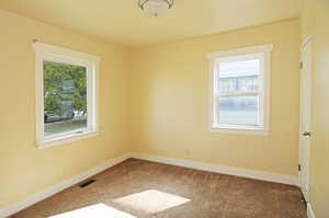 Carpeted empty room featuring a healthy amount of sunlight