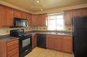 Kitchen with light tile patterned floors, sink, tasteful backsplash, a textured ceiling, and black appliances