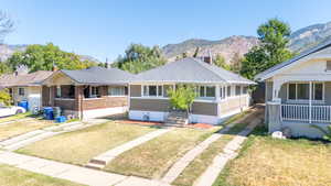 Ranch-style home featuring a mountain view, a front yard, and a porch