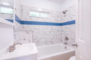 Full bathroom featuring tiled shower / bath, toilet, and vanity