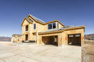 Property in mid-construction featuring a mountain view and a garage