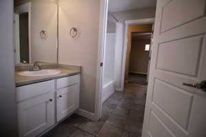 Bathroom featuring two vanities, tile patterned floors, and shower/bathtub servicing two bedrooms.