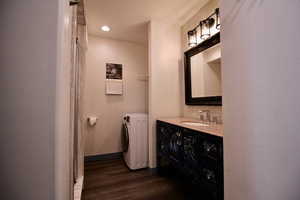 Bathroom with shower, washer/dryer, and vanity.