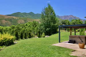 View of yard featuring a mountain view, a pergola, and a patio area