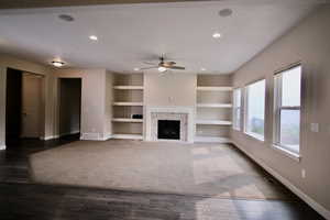 The great room awaits your personal touch; featuring built in shelves, a premium fireplace, a ceiling fan, and dark hardwood / wood-style floors, there is plenty of room for you to make this house your home.