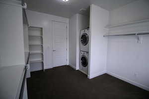 Huge walk-in closet included with Main bedroom featuring stacked washer and clothes dryer, carpet and bay windows.