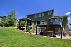 Back of property with a yard and a patio area