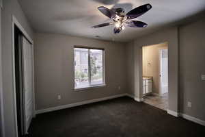 Bedroom featuring a textured ceiling, carpet, ceiling fan, and ensuite bath