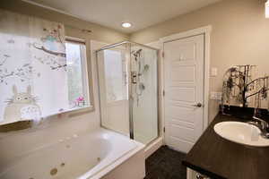 second-floor main bedroom bath that includes a vanity, toilet, shower, tub, and walk-in closet.