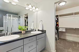 Primary bathroom with dual vanity, separate tub and shower, private toilet and walk-in closet