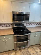 Kitchen with appliances with stainless steel finishes and backsplash