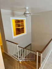 Stairs featuring a textured ceiling and hardwood / wood-style floors