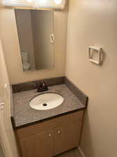 Half bathroom featuring vanity and toilet