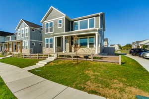 View of the front of the property with covered porch, a front lawn, and visitor parking