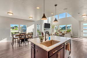 Kitchen featuring an island with sink, hanging light fixtures, and sink