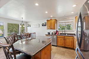 Kitchen featuring appliances with stainless steel finishes, decorative light fixtures, sink, and a wealth of natural light