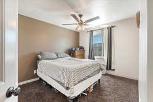 Carpeted bedroom featuring ceiling fan