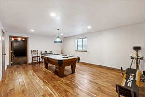 Rec room featuring pool table, a textured ceiling, and hardwood / wood-style flooring