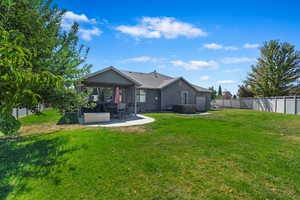 Back of house featuring a gazebo, a yard, and a patio area