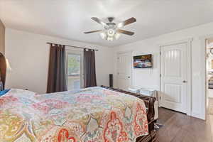 Bedroom with ceiling fan and dark hardwood / wood-style floors