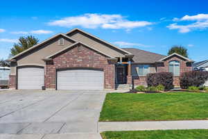 View of front facade featuring a garage and a front lawn