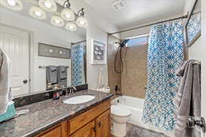 Full bathroom with vanity, toilet, and shower / bath combination with curtain