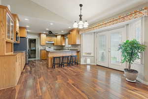 Kitchen featuring lofted ceiling, appliances with stainless steel finishes, dark hardwood / wood-style floors, and a breakfast bar area