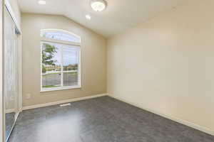 Spare room featuring lofted ceiling