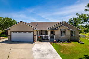 View of front of house featuring a front lawn, covered porch, and a garage