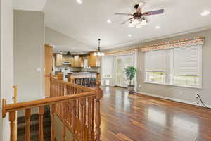 Interior space featuring ceiling fan with notable chandelier, lofted ceiling, dark hardwood / wood-style floors, and sink