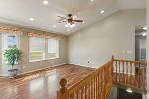 Interior space with vaulted ceiling, ceiling fan, and hardwood / wood-style flooring