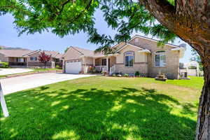 Ranch-style house with a garage, a front lawn, and central air condition unit