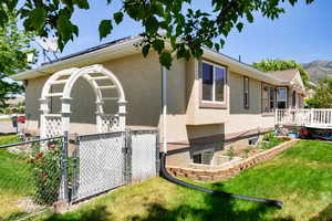 View of side of property with a deck with mountain view and a yard