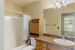 Full bathroom with shower / tub combo, vanity, and toilet