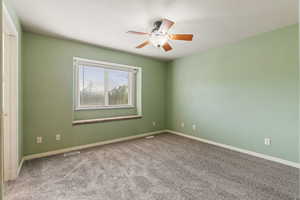 Carpeted empty room featuring ceiling fan