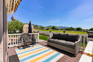 Wooden deck with a mountain view, an outdoor living space, and a storage shed