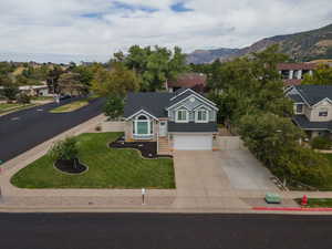 View of front of home with a garage, a mountain view, and a front yard