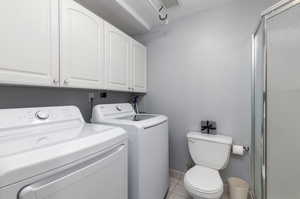 Clothes washing area featuring light tile patterned floors and washer and clothes dryer