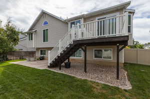 Back of house with a lawn and a patio area