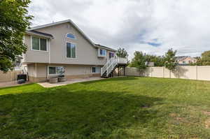 Rear view of property with a yard and a patio area