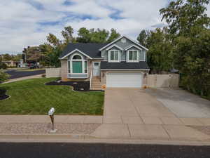 View of front of property featuring a front yard and a garage