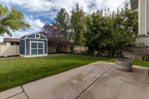 View of yard with a shed and a patio area