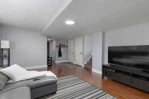 Living room with a textured ceiling and dark hardwood / wood-style floors