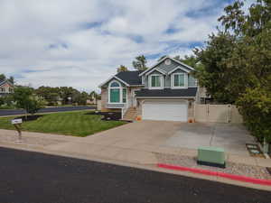 View of front of property featuring a garage and a front lawn