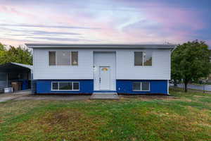 Split foyer home featuring a carport and a yard