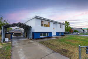 Raised ranch featuring a yard and a carport