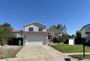 View of front facade with a garage and a front lawn