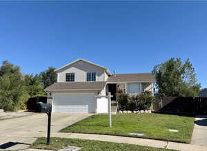 View of front of home featuring a front yard and a garage