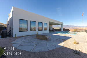 Back of property with a fenced in pool, a patio, and a mountain view