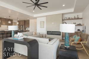 Living room with ceiling fan, a raised ceiling, and wood-type flooring